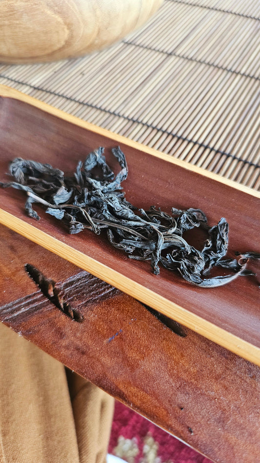From the high cliffs of Wuyi, this 2011 Rou Gui delivers a dance of fire, stone, and sweet spice. Smooth, structured, and deeply satisfying.

